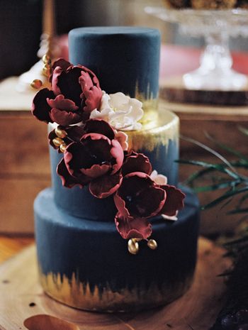 bold and dramatic wedding cake idea with metallic gold and berry colored flowers