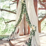 Woodland Wedding Arch with Billowy Fabric and a Cascade of Greenery