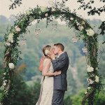 vintage green and white wedding arch with flower decorations