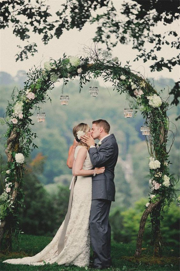 vintage green and white wedding arch with flower decorations