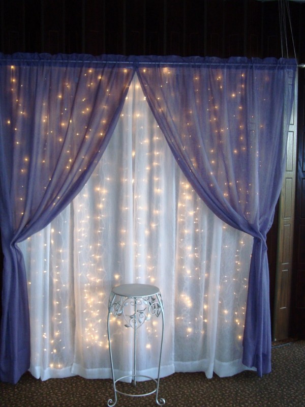 Curtain lights and sheer fabric would make a neat backdrop for a photo booth