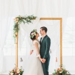 Gold frame wedding backdrop accented with rustic flowers