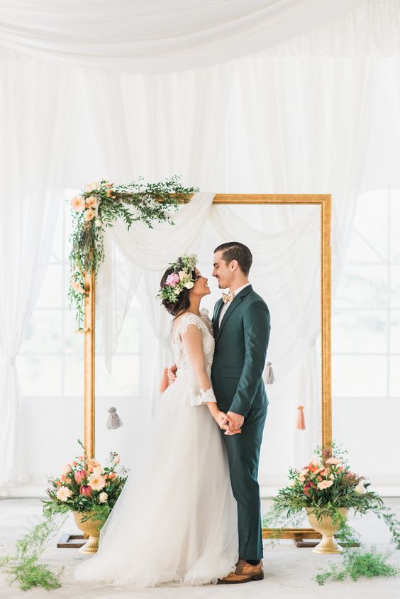 Gold frame wedding backdrop accented with rustic flowers