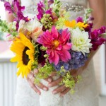 Wildflower bouquet of sunflowers, dahlias, roses, and craspedia balls.