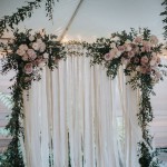 greenery arch with blush flowers and ribbon backdrop