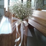 like the idea of flowers and tying them to the pews