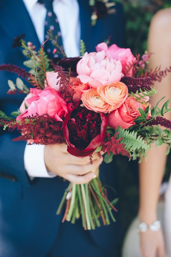 navy blue suite and dramatic bouquet of peonies and ranunculus roses