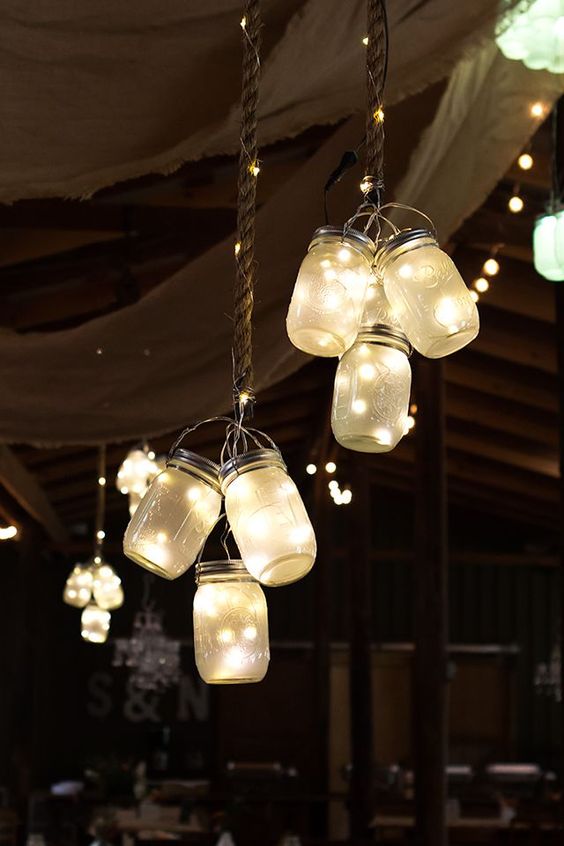  Clusters of frosted LED mason jar lights hung from the ceiling at this rustic barn wedding. 